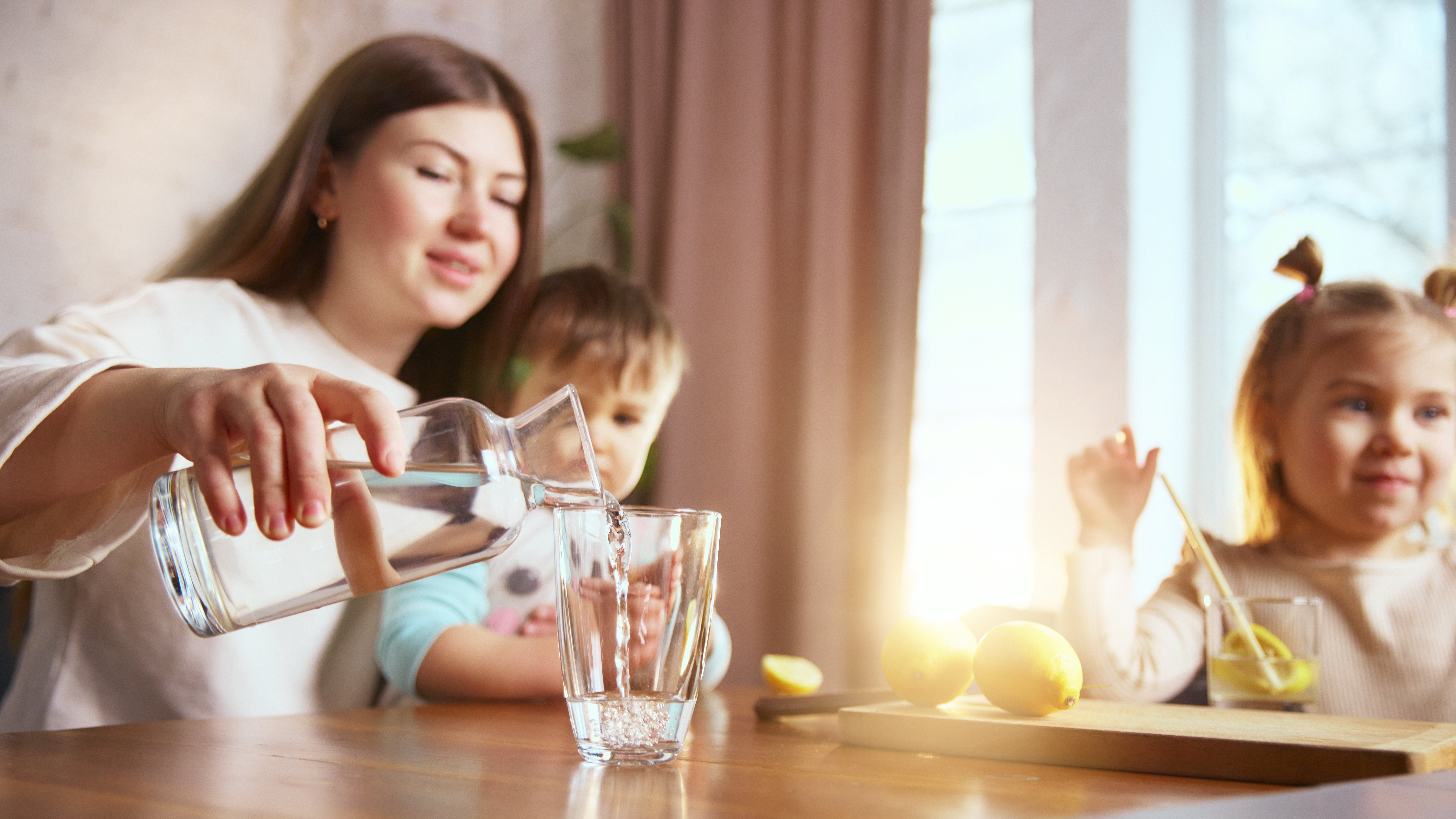 Adobe Stock image of a woman pouring water for her children.